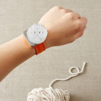 Reihenzähler geklippt an an das magnetische Armband von Cocoknits. Armband ist an ein Handgelenk angelegt.